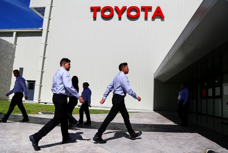 FILE PHOTO: Employees walk at the Toyota Motor Corp new
