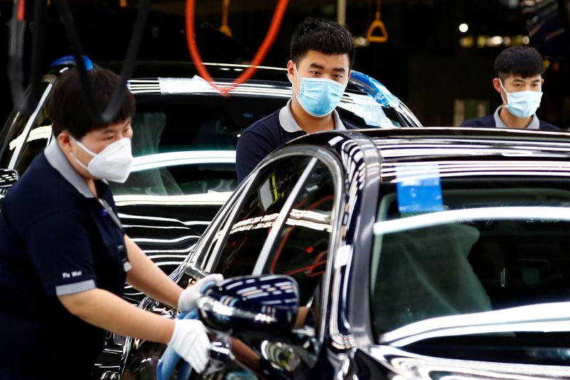 Employees wearing face masks work at a plant of Daimler-BAIC
