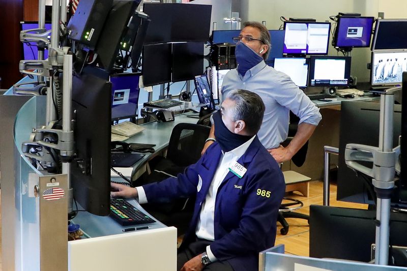 Traders wearing masks work, on the first day of in-person