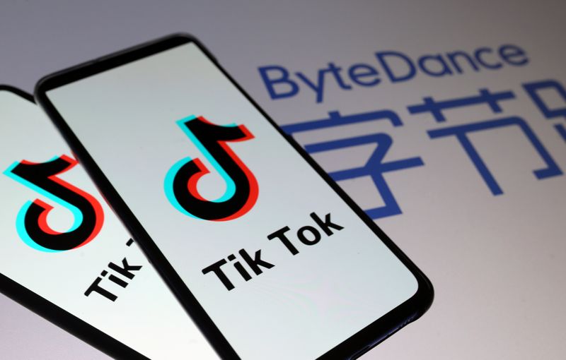 Tik Tok logos are seen on smartphones in front of