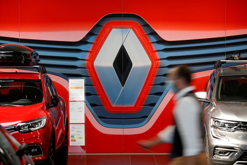 FILE PHOTO: An employee walks past a logo of Renault