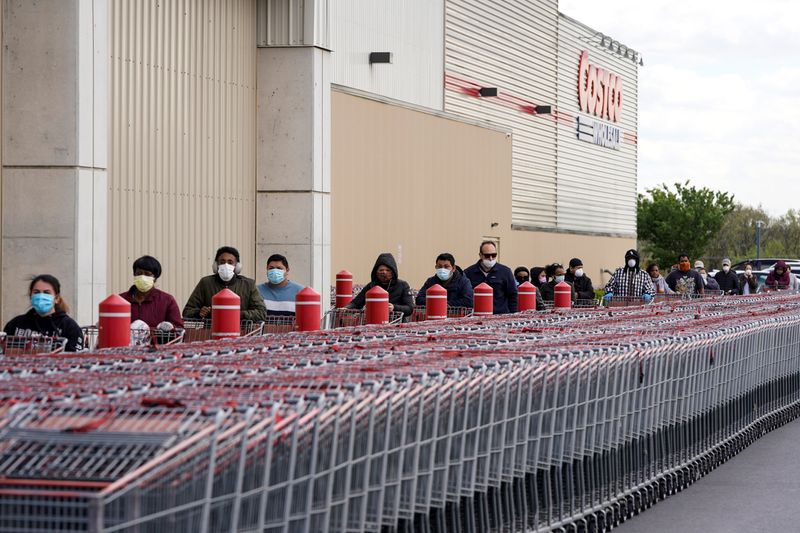People wear masks as they wait to enter a Costco