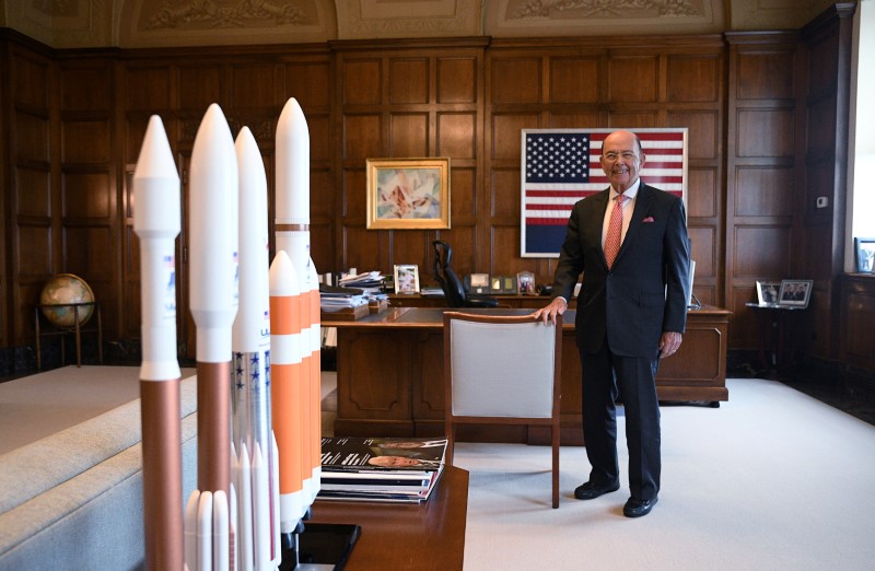 U.S. Secretary of Commerce Ross poses near rocket models during