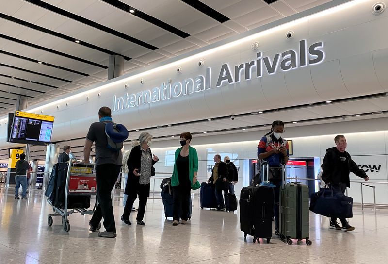 Travellers are seen wearing protective face masks at Heathrow Airport,