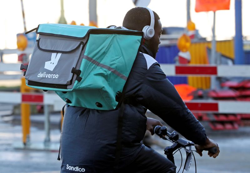 A courier for food delivery service Deliveroo rides a bike