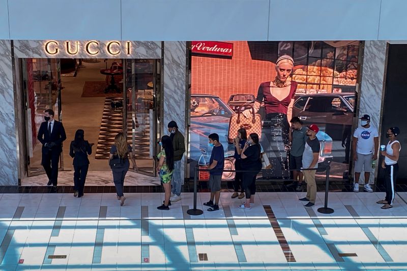 Customers line up to enter a Gucci fashion store at