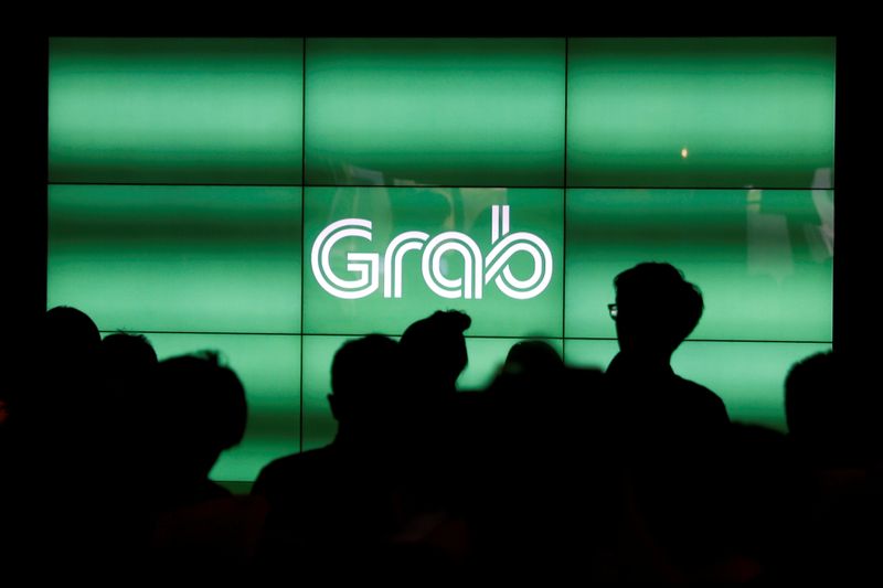 FILE PHOTO: People wait for the start of Grab’s fifth