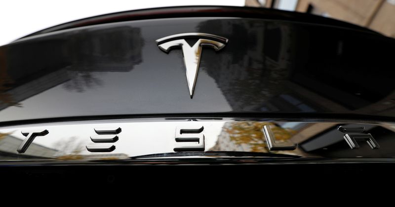 The company logo is pictured on a Tesla Model X