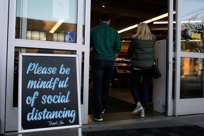 FILE PHOTO: Shoppers enter a grocery store near a sign