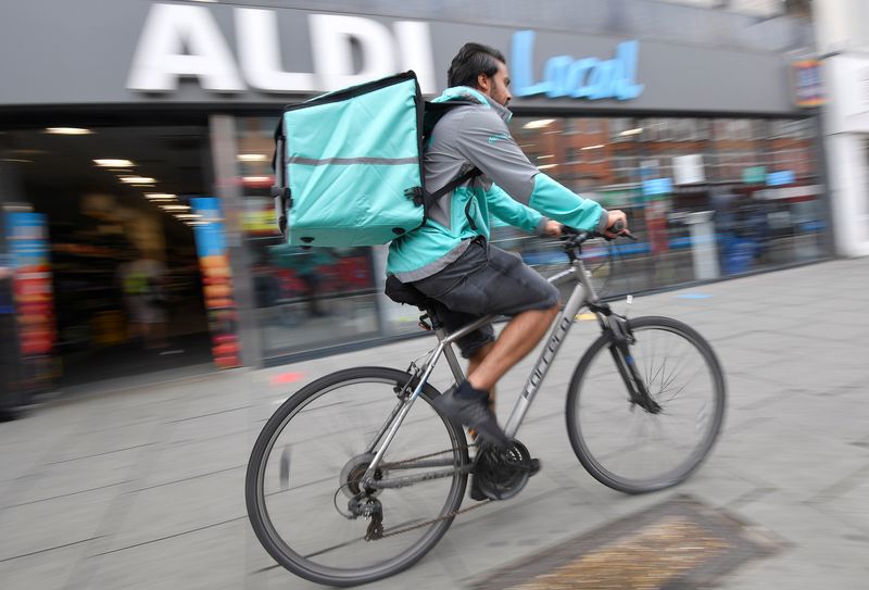 Abdelaziz Abdou, a Deliveroo delivery rider, poses with a bag