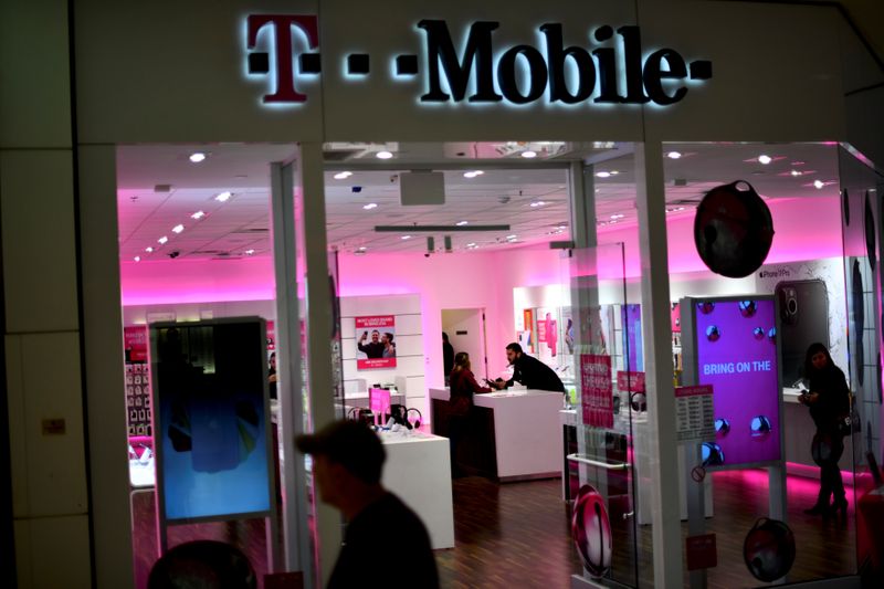 A T-Mobile employee assists a customer as holiday shopping accelerates