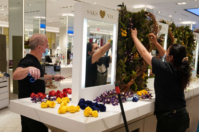 Workers put up a flower display at Saks 5th Avenue
