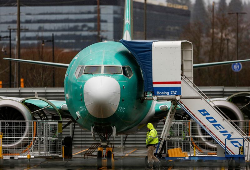 An employee walks past a Boeing 737 Max aircraft seen