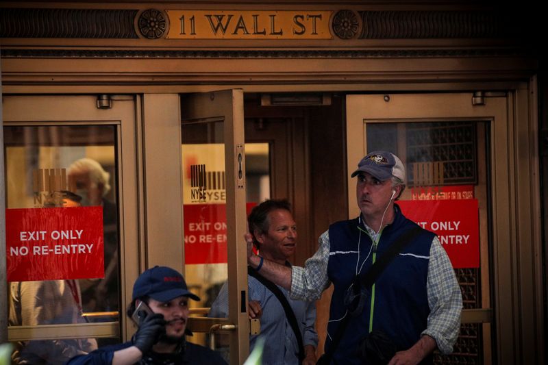 Traders exit the 11 Wall St. door of the NYSE