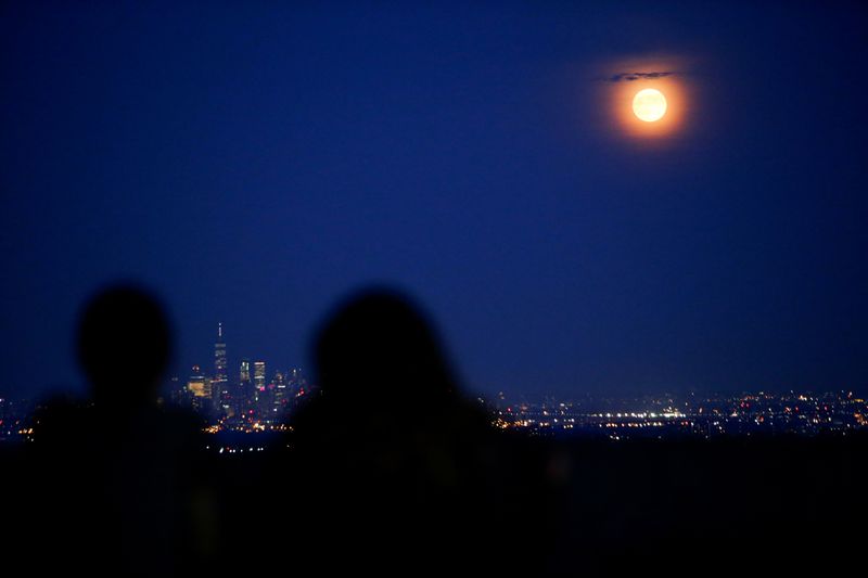 FILE PHOTO: People watch the full moon while it rises