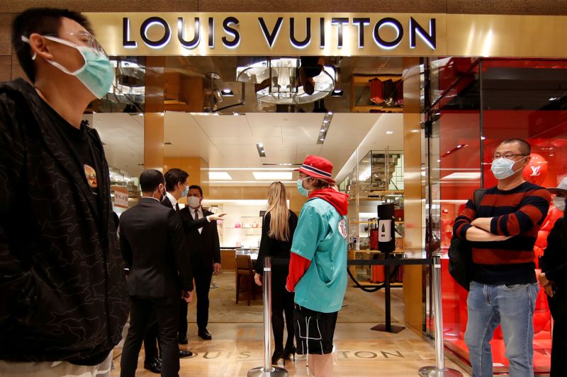 FILE PHOTO: Customers stand in front of a Louis Vuitton