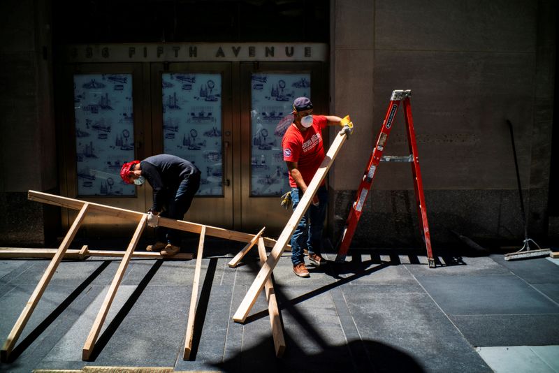 FILE PHOTO: Workers remove boards from windows in a local