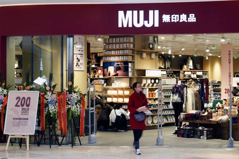Woman walks outside a newly opened Muji store at a