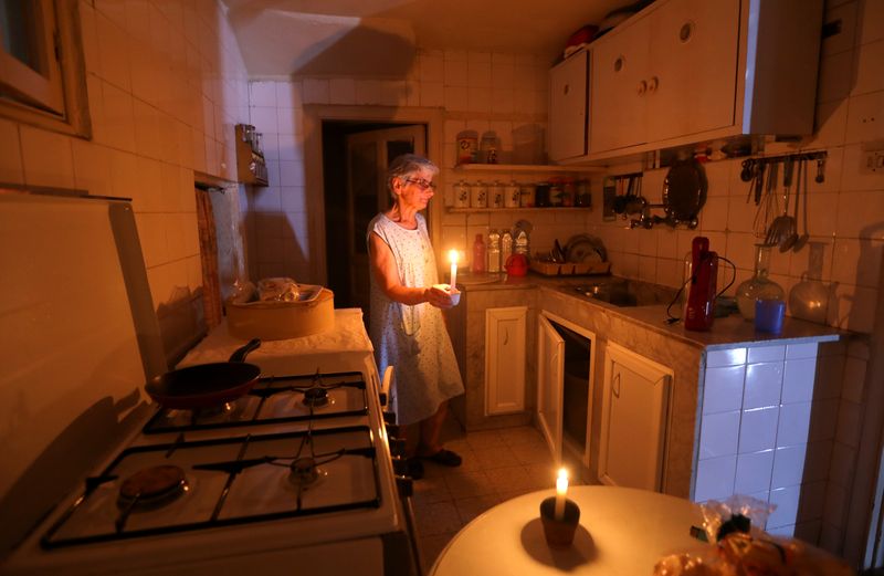Samira Hanna,70, walks in her kitchen as she holds a