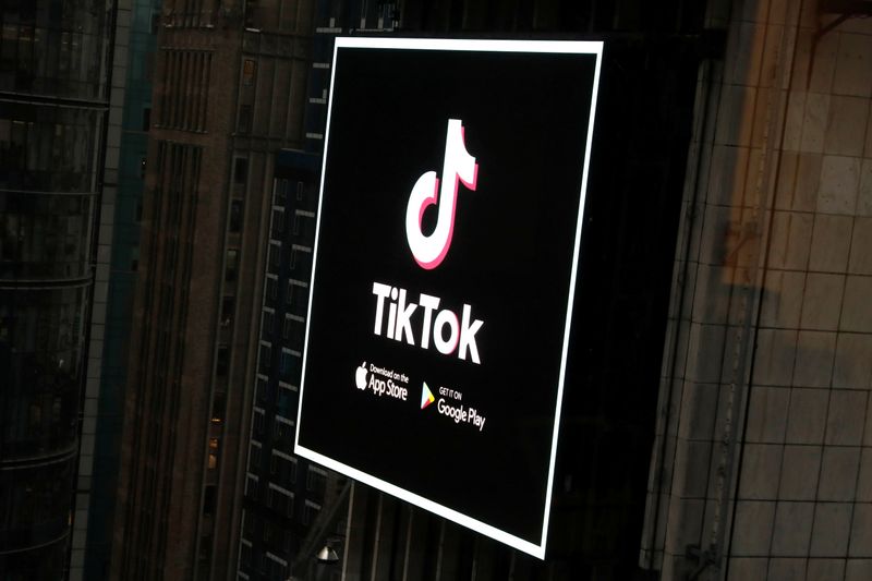 The TikTok logo is seen on a screen over Times