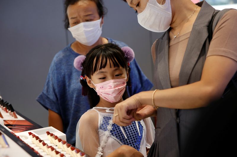 Customers wearing face masks shop at a Chinese cosmetics brand