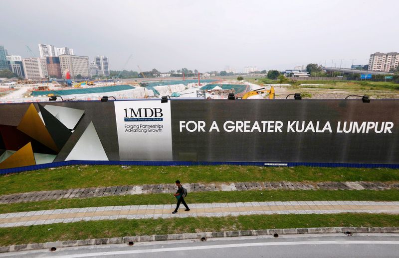 FILE PHOTO: A man walks past a 1 Malaysia Development