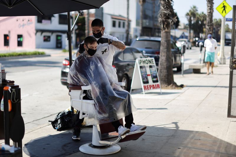 Keith Huerta, 30, cuts the hair of Nick Parr, 25,