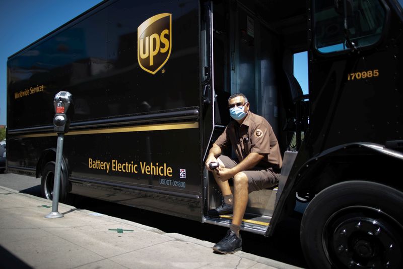 UPS Driver Gilbert Lopez poses with his electric UPS truck,