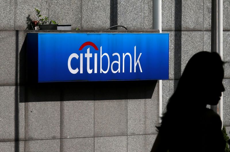 FILE PHOTO: A woman walks past a Citibank logo displayed