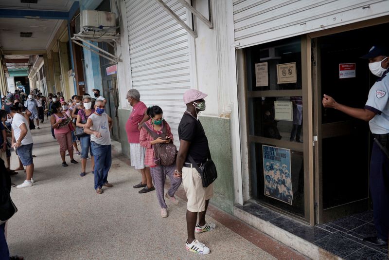 People wait in line to enter a currency exchange office