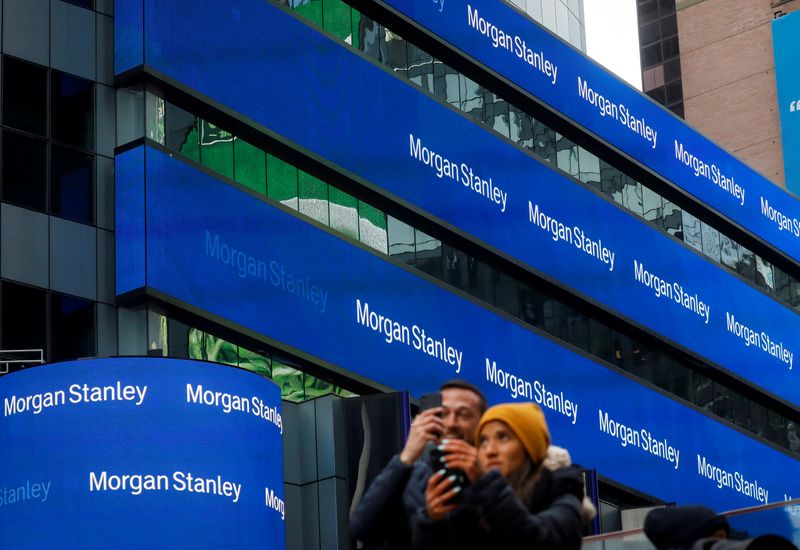 People take photos by the Morgan Stanley building in Times