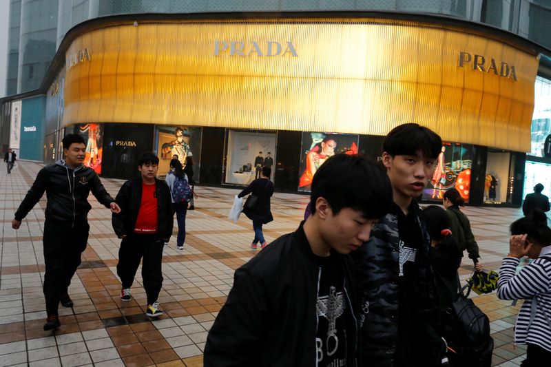 FILE PHOTO: People walk past a Prada luxury fashion boutique