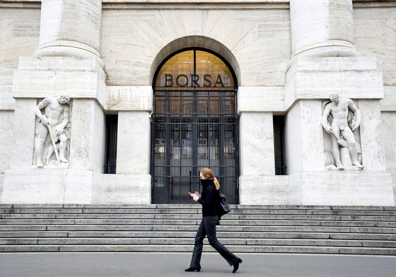 FILE PHOTO: A woman passes the Italian Stock Exchange in