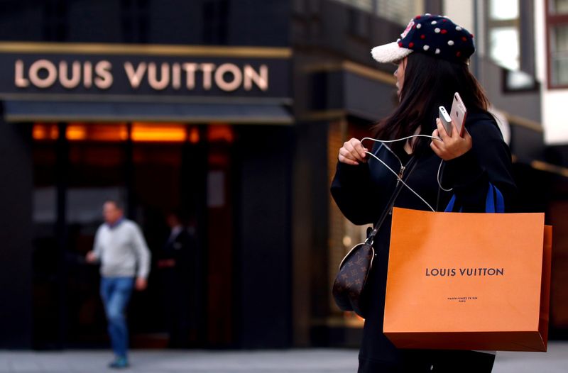FILE PHOTO: Woman with a Louis Vuitton-branded shopping bag looks