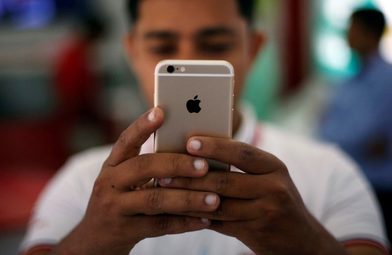 FILE PHOTO: A salesman checks a customer’s iPhone at a