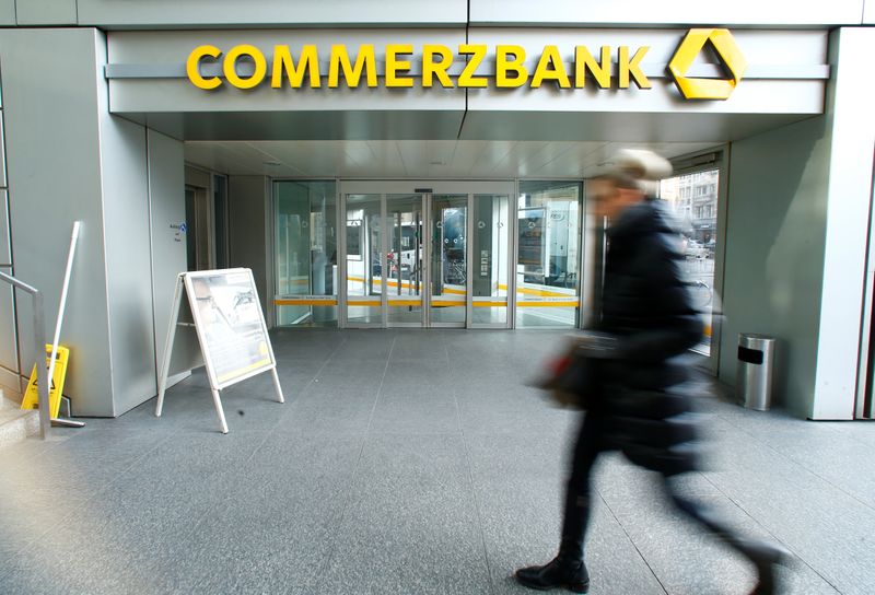 A woman walks past a branch of Commerzbank before the