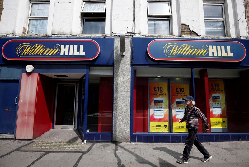 A pedestrian walks past a William Hill betting shop in