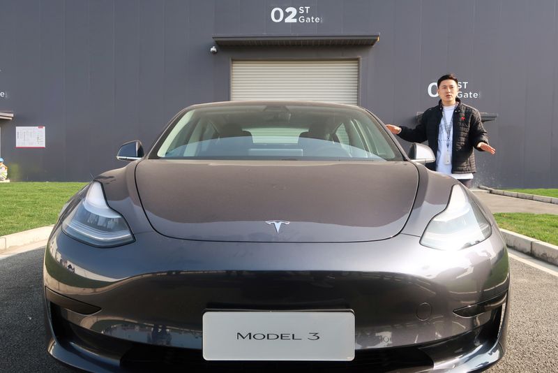 Staff member explains the China-made Tesla Model 3 vehicle at