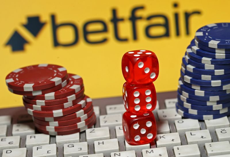 Betfair logo is seen behind a keyboard, gambling dice and