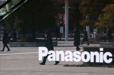 FILE PHOTO: People are reflected in a sign at Panasonic