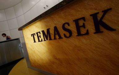 FILE PHOTO: Woman passes a logo of state investor Temasek