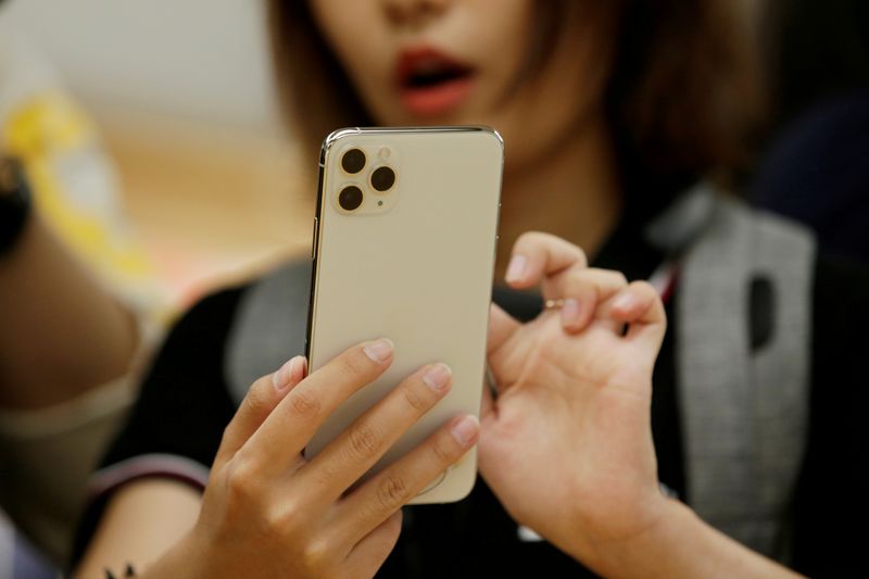 FILE PHOTO: A woman holds an iPhone 11 Pro Max