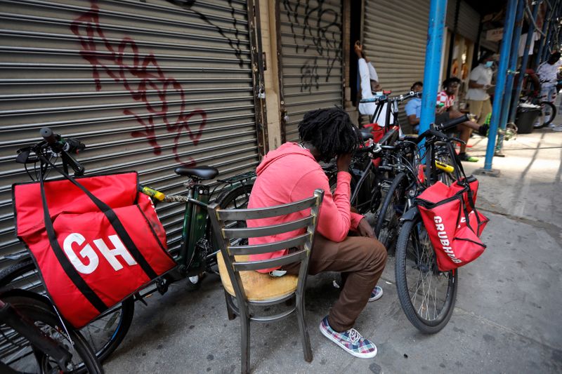 “Grubhub” delivery riders congregate between deliveries in midtown Manhattan in