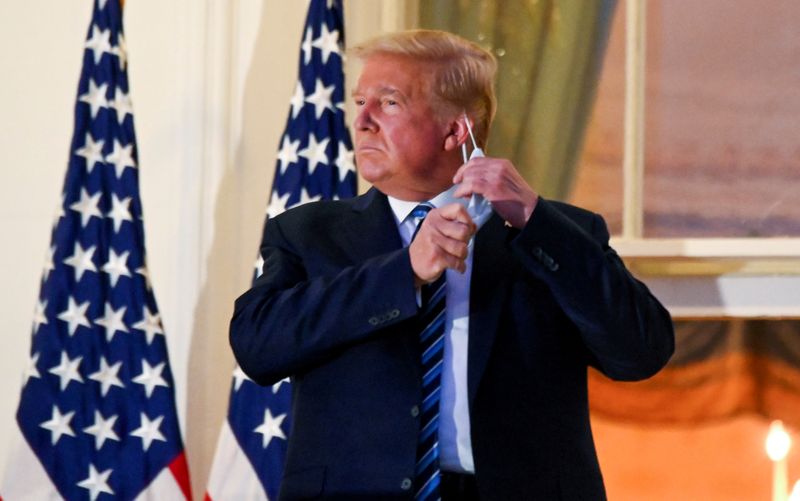 FILE PHOTO: U.S. President Donald Trump pulls off his face