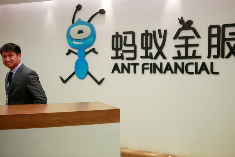 FILE PHOTO: Employee stands next to the logo of Ant