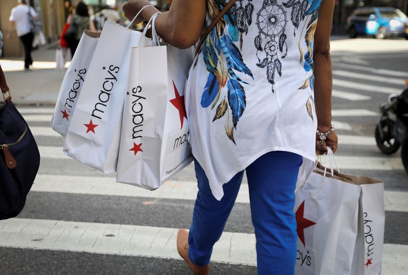A woman carries shopping bags from Macy’s department store in