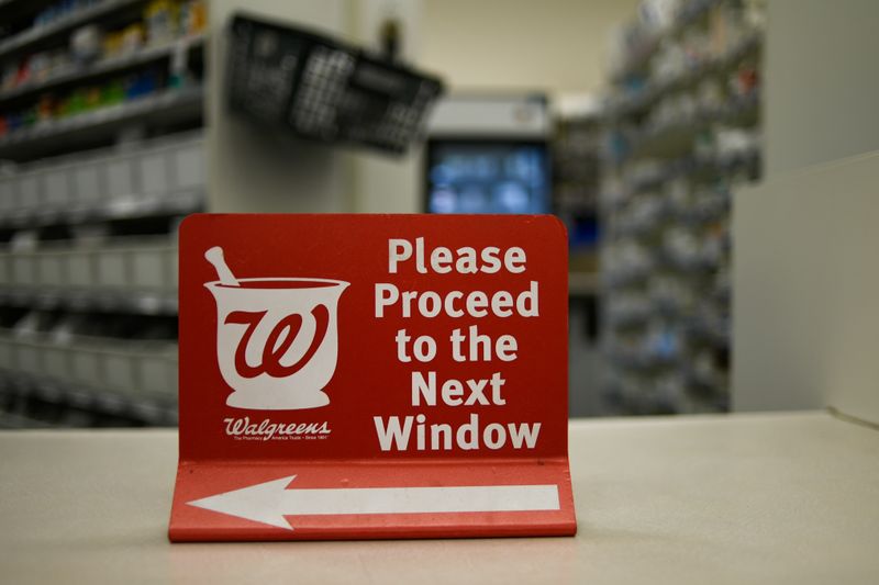 A sign rests on a counter at a Walgreens pharmacy