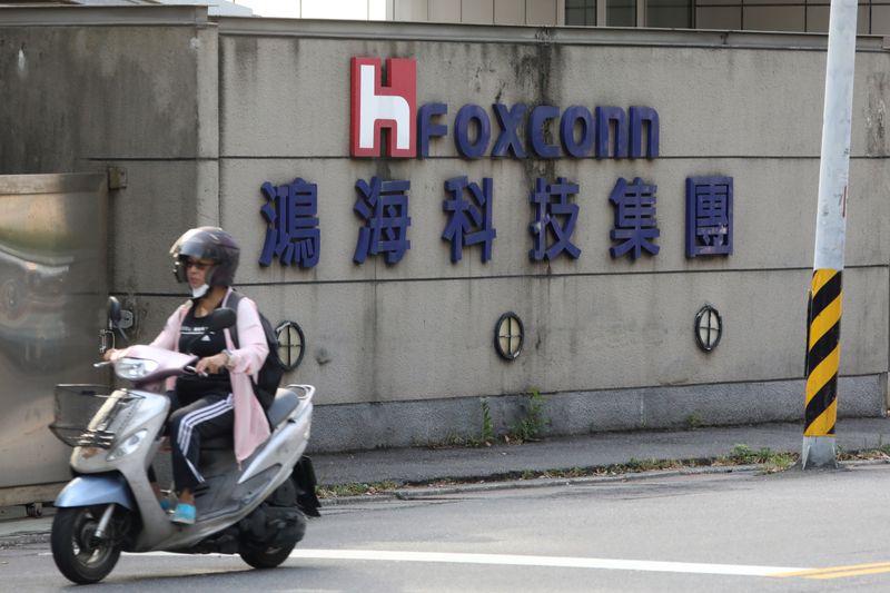 A person riding a scooter wears a mask amid the