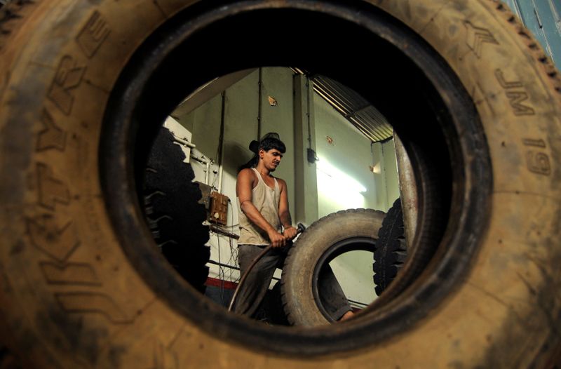 FILE PHOTO: A worker retreads a used rubber tyre at