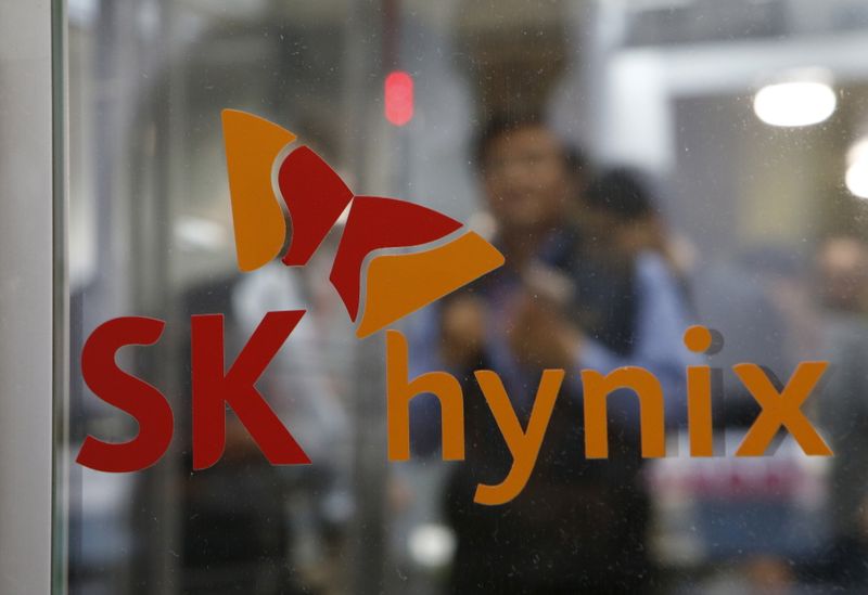 Employee walk past the logo of SK Hynix at its
